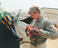 Dr. Bob Arnot holds a child in Darfur