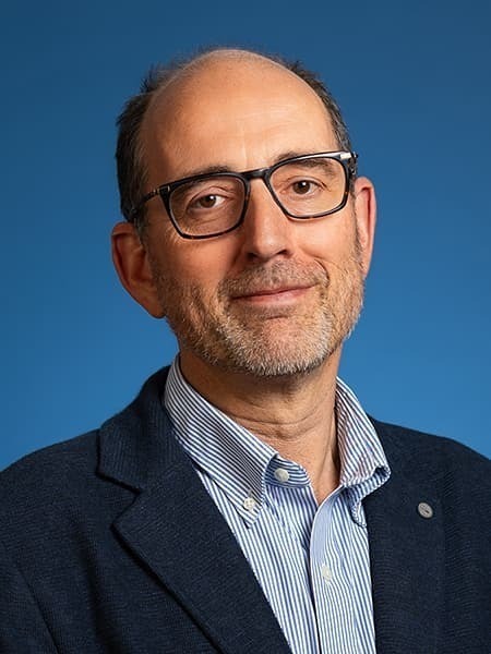 Theology associate professor Abraham Winitzer, who appears as a white male with glasses sitting in front of a blue background.