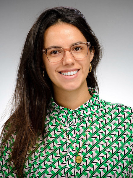 Vicky Barone, presenting as a caucasian woman with long brown hair and glasses wearing a patterned green shirt.